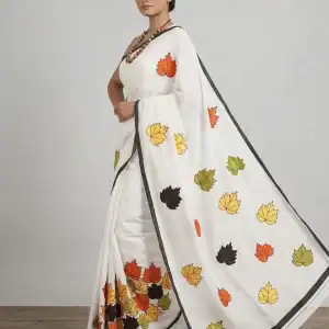 Elegant white cotton saree with colorful leaf patchwork and black border, perfect for traditional an.